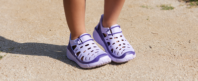 girls standing in dirt with purple joybees strekking shoes on