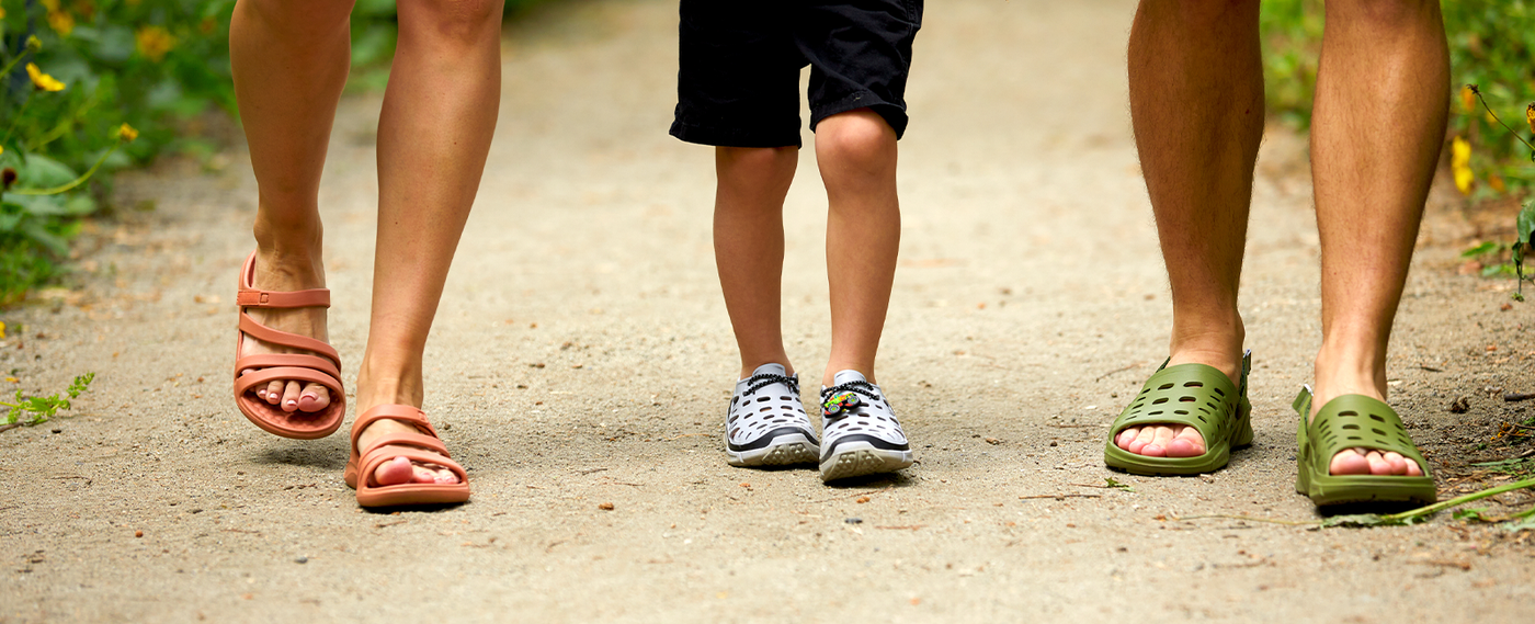 mom, dad, and son all walking in their joybees shoes on a dirt path